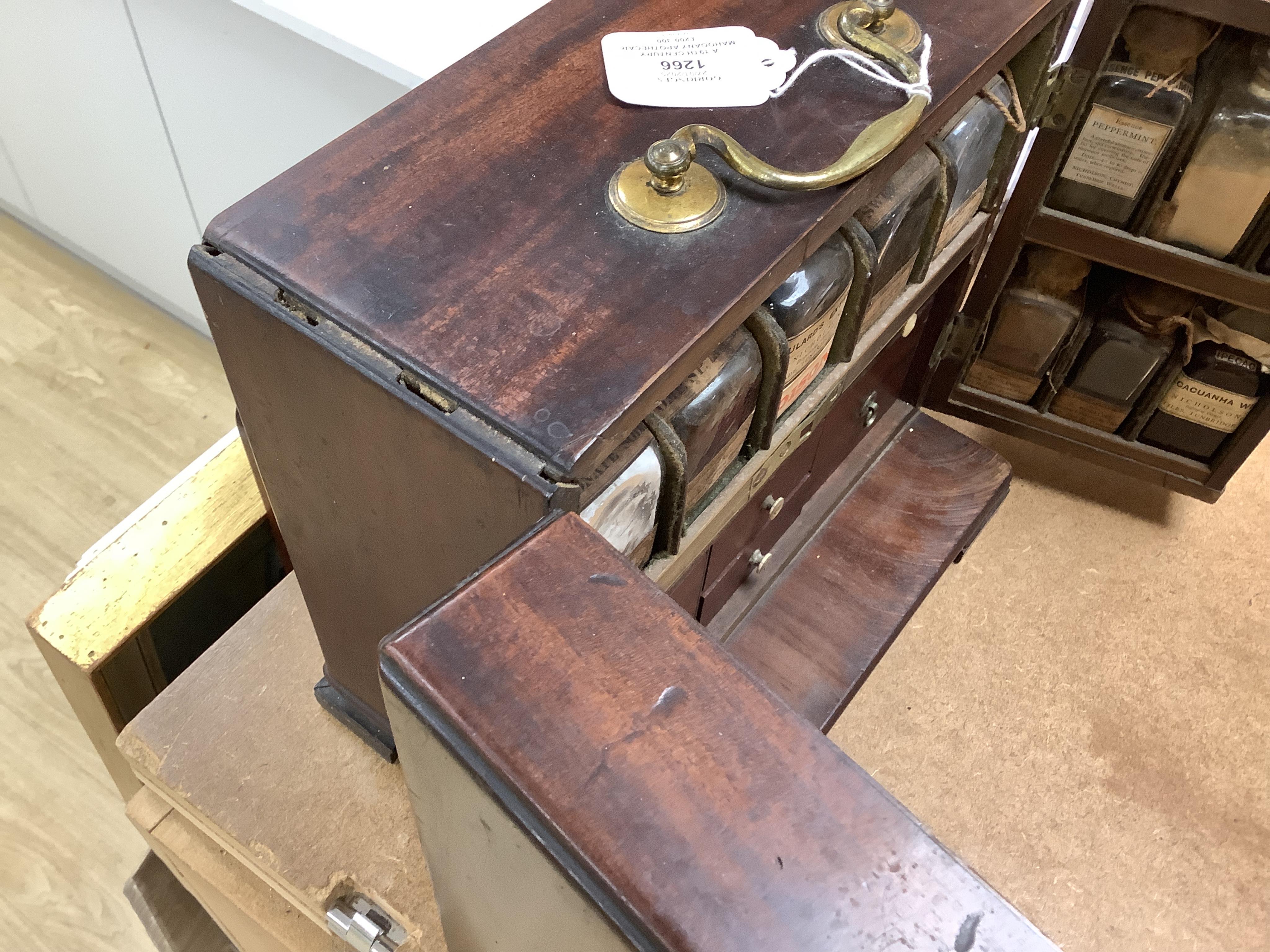 A 19th century mahogany apothecary cabinet, containing 20 bottles of various medicinal compounds and poisons, some sealed, all with paper labels, mainly for ‘C. Woollven, Operative & Dispensing Chemist, 108, High Street,